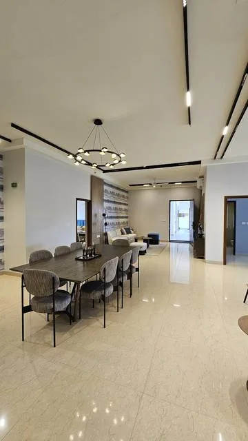 Dining area with built-in joinery and layered ceiling lighting in a Bangalore apartment