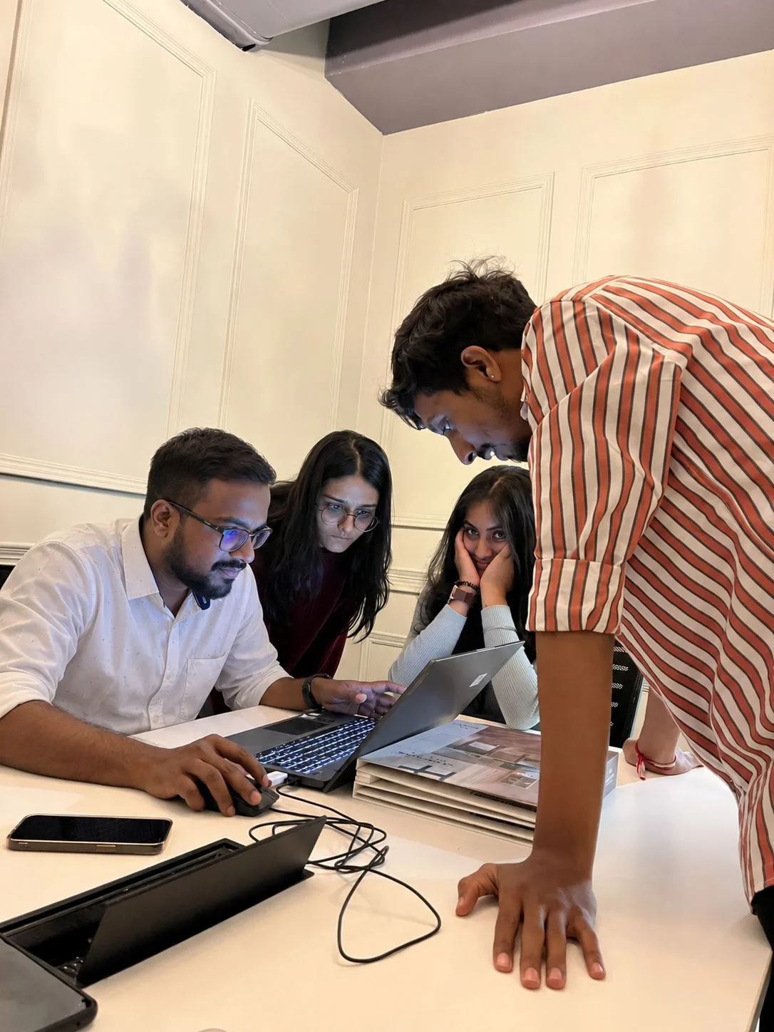 Four of our designers around a laptop at the start of a project.
